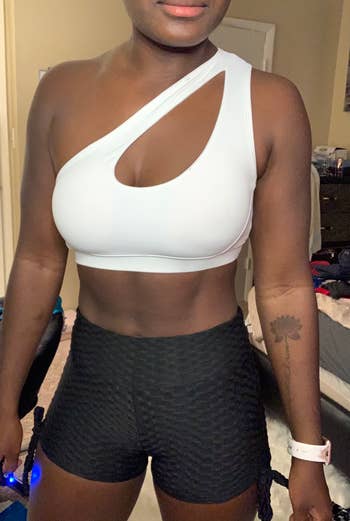 reviewer wearing a white one shoulder sports bra