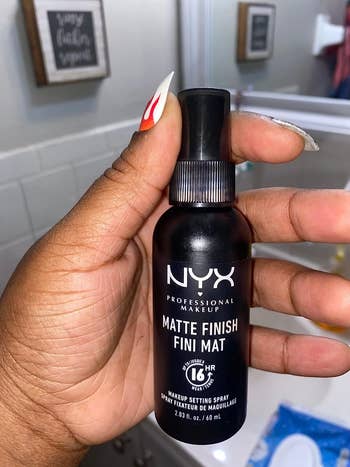 reviewer holding up the nyx spray