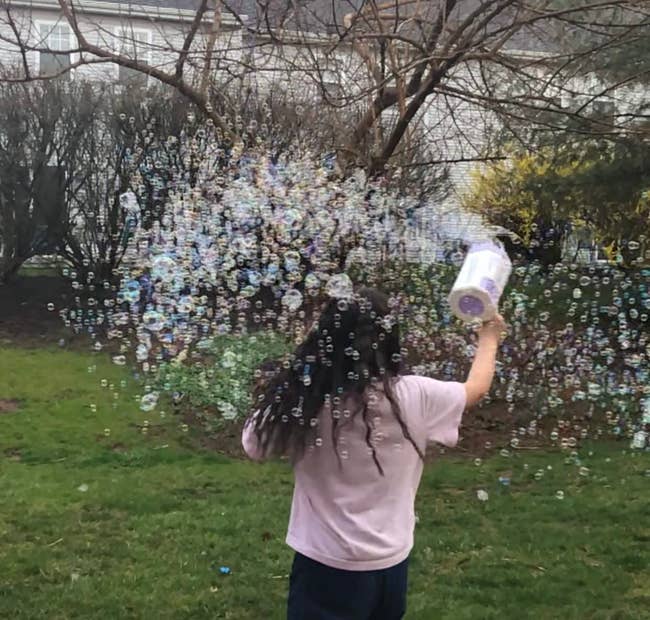 child runs through cloud of bubbles