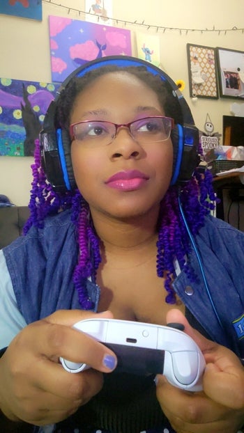 Writer wearing headphones while holding her Xbox controller
