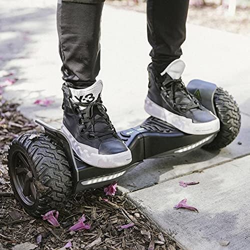 Model on all black hoverboard on dirt and cement