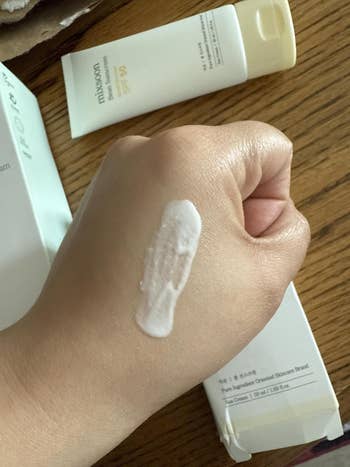 reviewer shows sunscreen lotion applied connected  hand