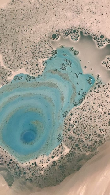 reviewer photo of blue soapy water in their bath