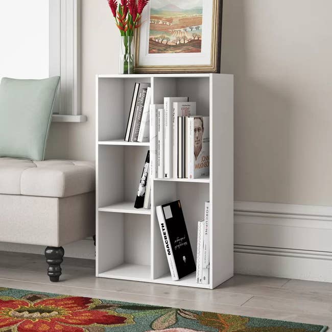 the white bookcase with five cubbies of different sizes