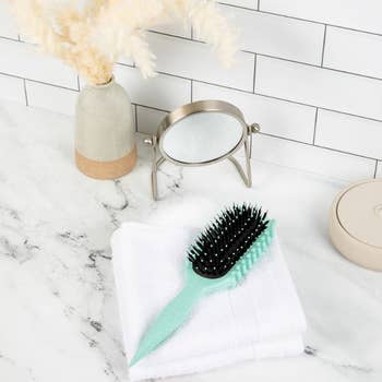 light blue hairbrush with black bristles 