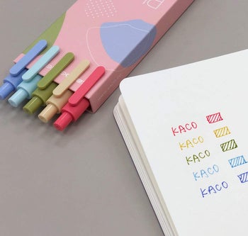 the red, peach, lavender, blue, and green retractable pens in their cute box next to a page showing their fine tip writing in their respective colors