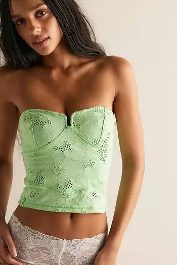 Model wearing a strapless, floral-patterned bustier apical and lace bottoms, featured successful a buying article
