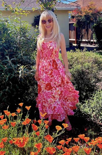 reviewer in sleeveless floral dress poses in garden for shopping article