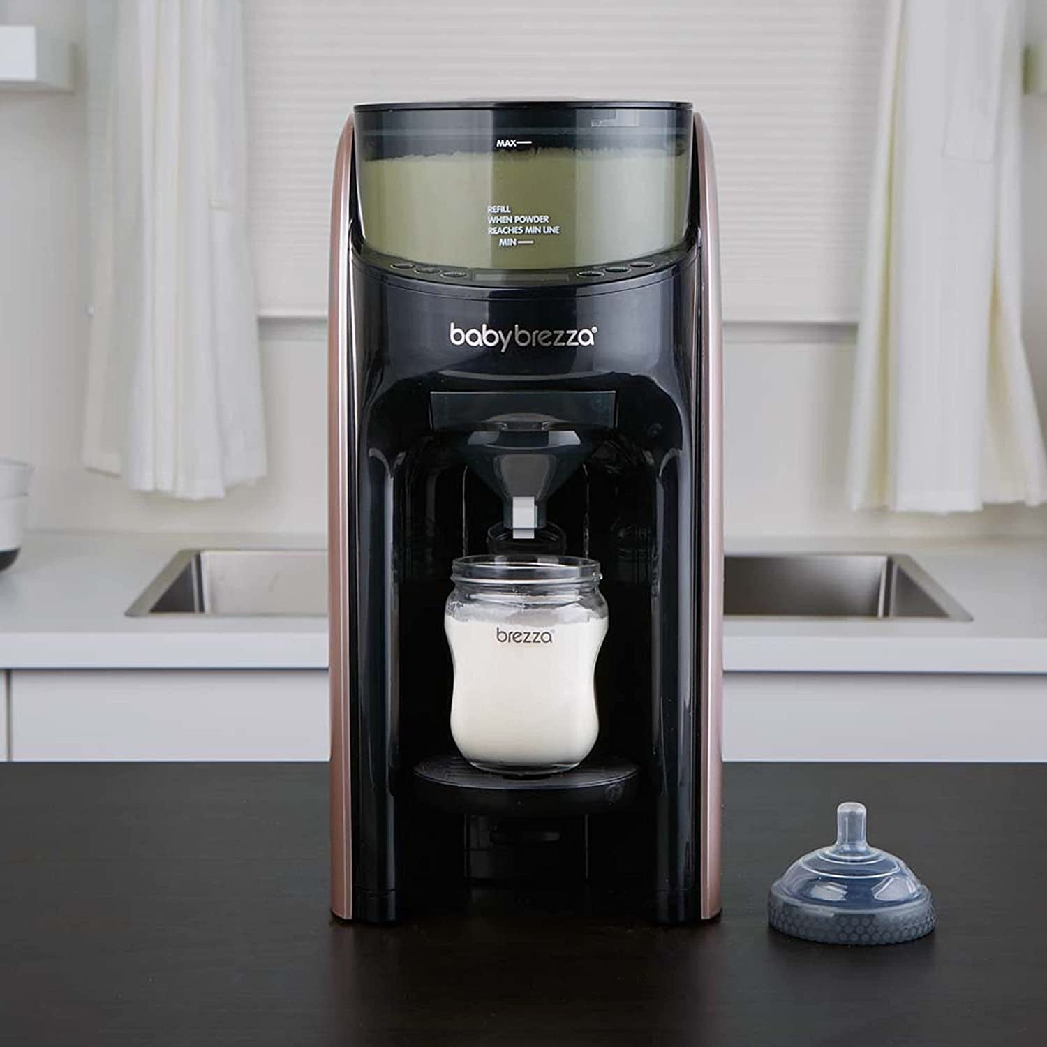 the rose gold baby brezza machine making a bottle