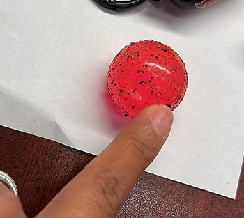 a reviewer photo of the inner sticky ball removed showing crumbs and dirt stuck to it 