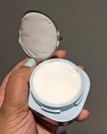 reviewer holding packaging with the cap off of product
