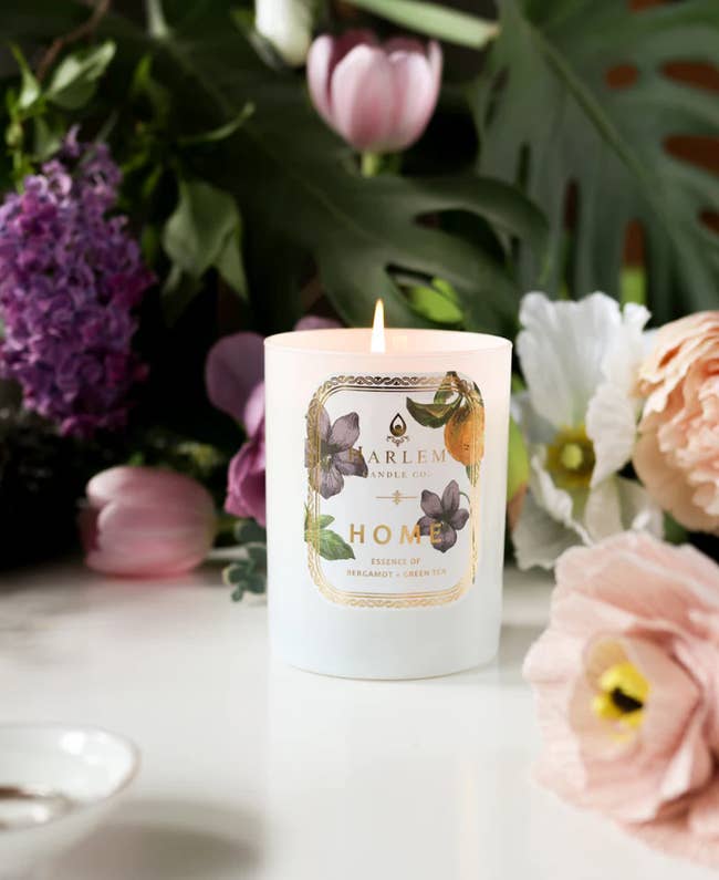 A lit candle successful  a floral setting, labeled 