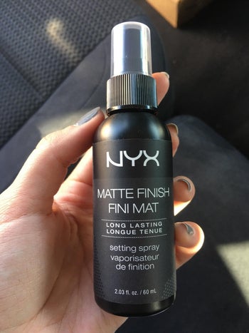 a reviewer holding the spray bottle