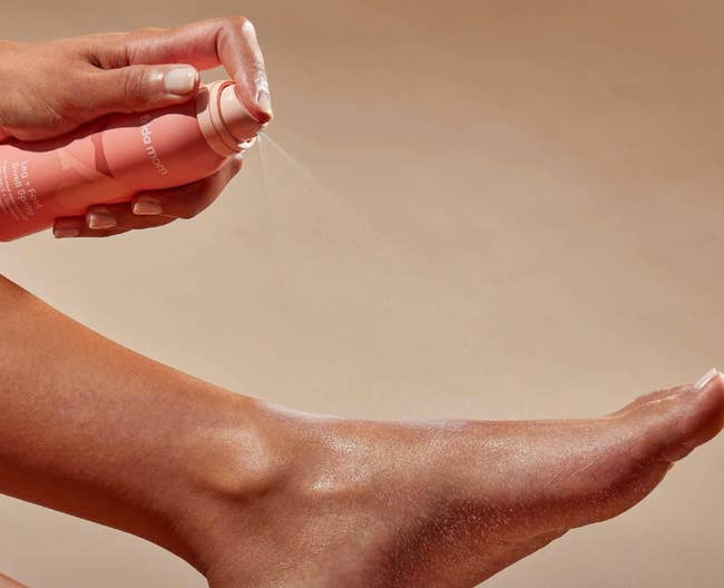 Hand applying spray skincare product to leg, emphasizing hydration and care. Product suited for shopping in beauty category