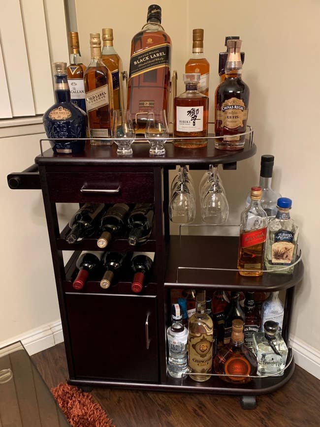 Reviewer image of the brown bar cart filled with bottles and glasses