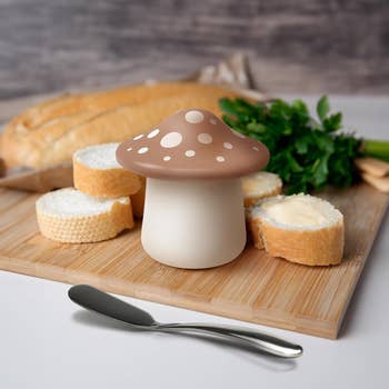 mushroom shaped butter keeper on a counter next to buttered bread 