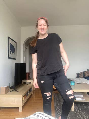 Reviewer in casual style with black distressed jeans and a plain black tee