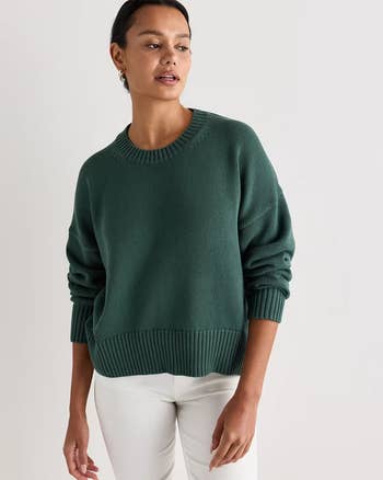 A idiosyncratic   models a cozy knit sweater paired with sleek, light-colored pants, cleanable   for a casual buying  outing