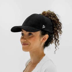 sideview of a model wearing the hat in black with their hair in a high ponytail