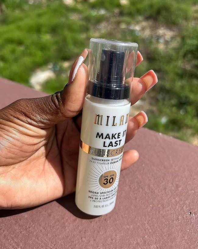 Hand holding Milani Make It Last Sunscreen Setting Spray SPF 30
