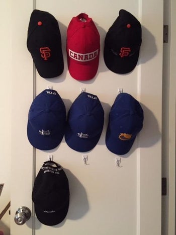 reviewer's hat collection held up with clear command hooks