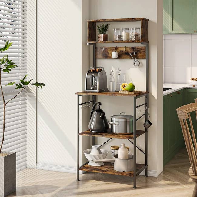 the baker's rack holding kitchen appliances and other items