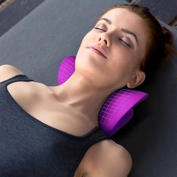 A exemplary  lying connected  her backmost  utilizing a cervix  enactment    pillow for relaxation, wearing a vessel  top