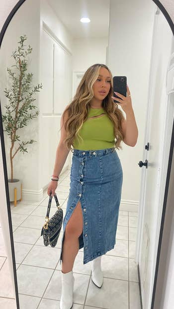 reviewer posing in a mirror, wearing the denim skirt