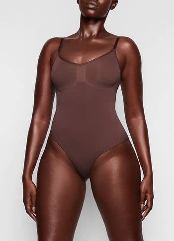 model in the dark brown bodysuit