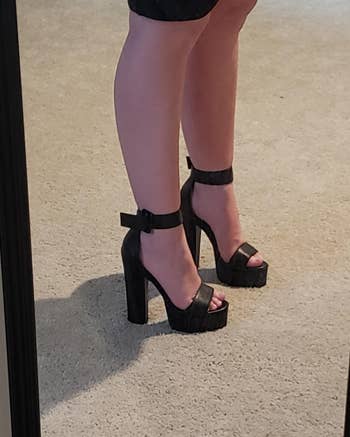 reviewer mirror selfie wearing high-inch black heels