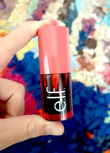 Person holding e.l.f. lipstick against a textured background