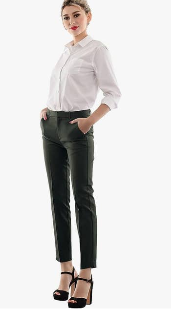 A model wearing the pants in black with a white button down shirt
