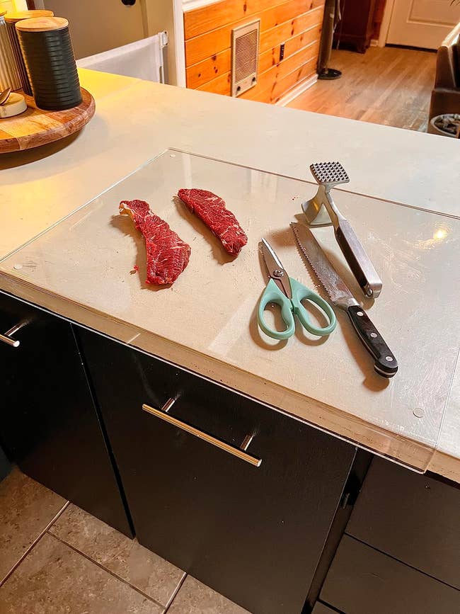 Raw meat, room  scissors, a nutrient   tenderizer, and a weapon  are placed connected  a cutting committee  successful  a location  kitchen