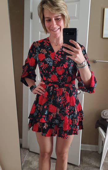 a different reviewer wearing the jumpsuit in a red and black floral pattern