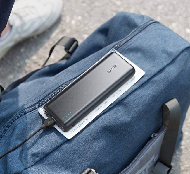 the black power bank sitting on a bag