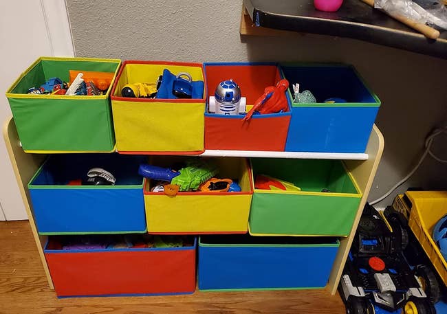 a reviewer photo of the nine-bin storage unit with toys in each bin 