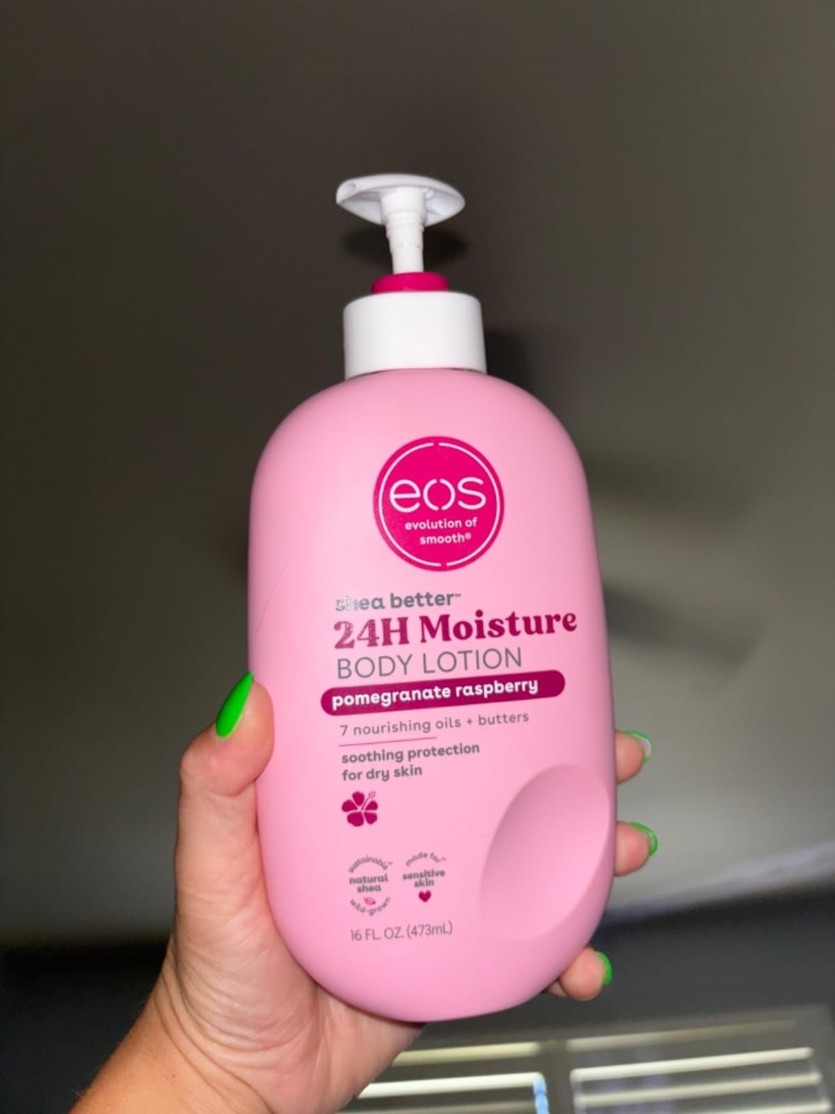 Tangan memegang EOS Body Lotion dalam aroma Delima Raspberry
