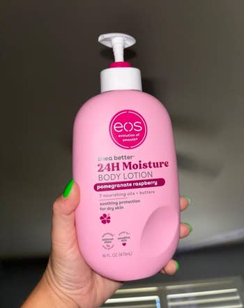 Tangan memegang EOS Body Lotion dalam aroma Delima Raspberry