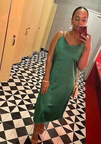 reviewer wearing the green slip dress with tan heels