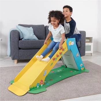 two children playing on the indoor slide