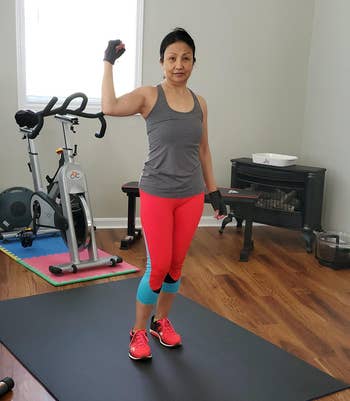 reviewer standing on large exercise mat in front of spin bike
