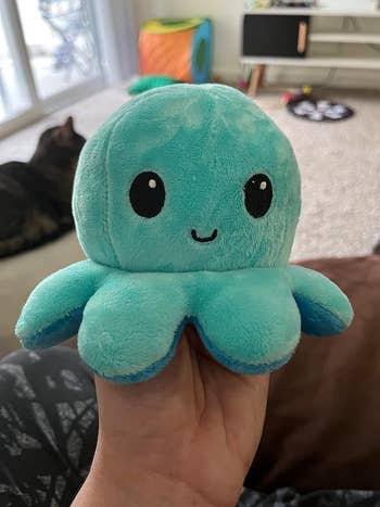 one side of a plush octopus looking happy