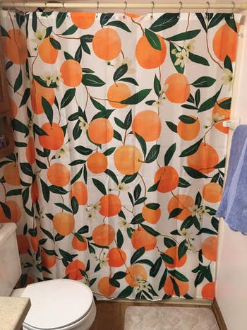 orange-printed shower curtain in bathroom
