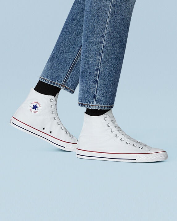 model's feet wearing white high-top Converse