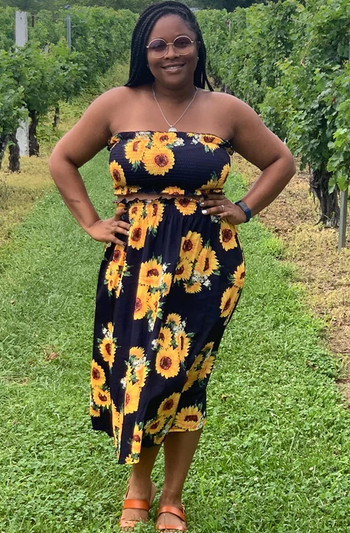 reviewer wearing the black sunflower print skirt set