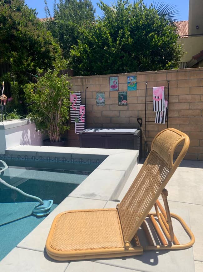 a reviewer's rattan lounge chair on a pool deck