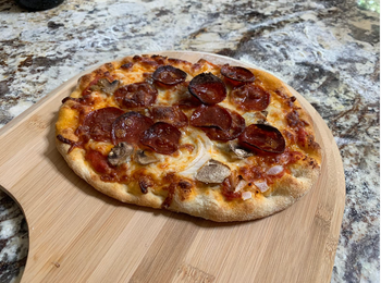 a perfectly cooked pepperoni pizza on the stone 