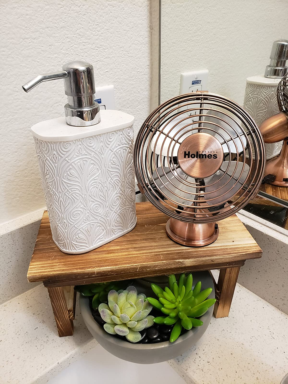 a reviewer photograph  of a tiny  copper instrumentality   sitting connected  a woody  basal   adjacent  to a manus  soap vessel  