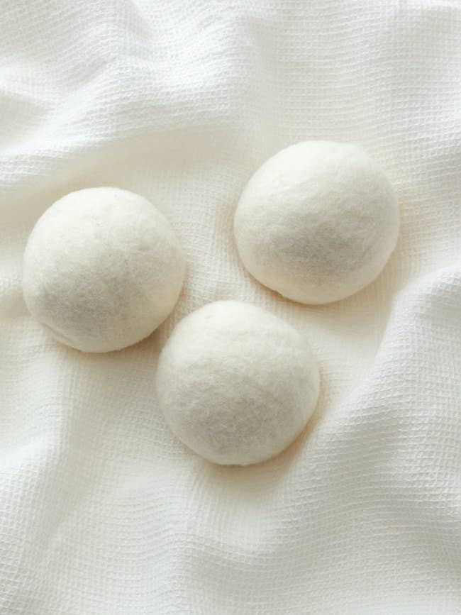 three white wool dryer balls