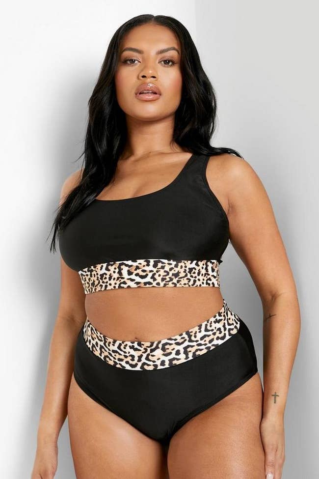 model posing in black and leopard print bathing suit